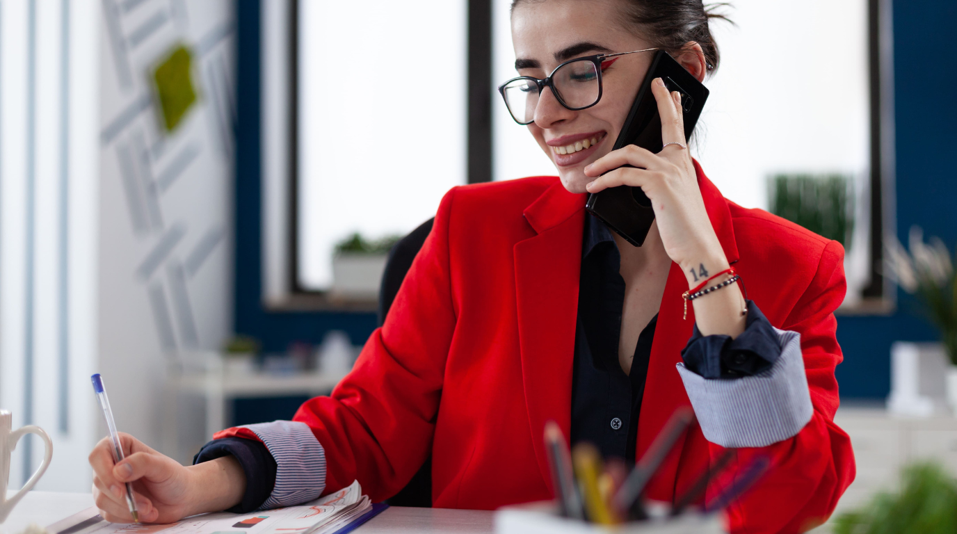 mujer de chaqueta roja atendiendo a un cliente por telefono